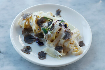 italian food pasta dish tagliatelle truffle sauce in close up on a dining table