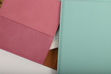 Leather passport wallet in different colors. Concept shot, top view. Custom background, Vacation and tourism concept. Free space for text. Stylish accessory for travelling