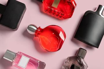 Bottles of luxury perfume on pink background