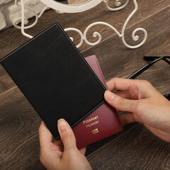 Leather passport wallet in black colors. Concept shot, top view. Custom background, Vacation and tourism concept. Free space for text. Stylish accessory for travelling