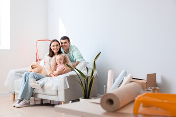 Happy family sitting on sofa during repair of their new house