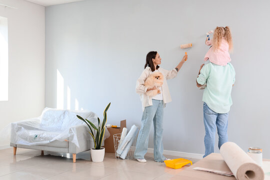Happy family painting wall during repair of their new house