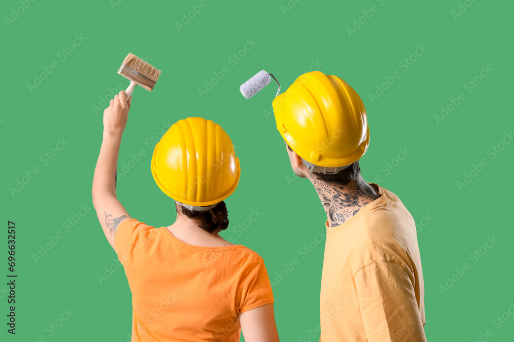 Poster young couple with paint brush and roller on green background