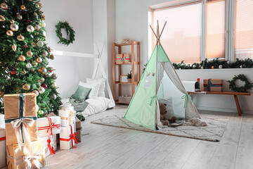 Cozy children's bedroom interior with tent, gifts and decorated Christmas tree