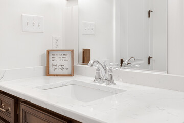 Guest Bathroom Vanity with Dual Sinks and Inspirational Quote Plaque on a Marble Countertop in a...