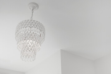 Crystal Beaded Chandelier Emitting a Warm Glow in a Contemporary Room with Minimalist Decor, Copyspace