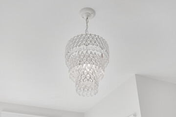 Crystal Beaded Chandelier Emitting a Warm Glow in a Contemporary Room with Minimalist Decor
