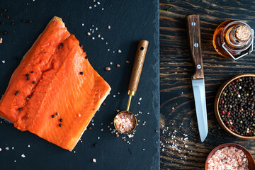 salmon fillet with salt and pepper on a stone slab.