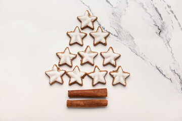 Christmas tree made of stars shaped cookies and cinnamon on white grunge background