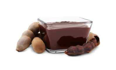 Bowl of tasty tamarind sauce and fresh pods isolated on white
