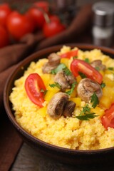 Tasty cornmeal with tomatoes, pepper and mushrooms in bowl on table, closeup