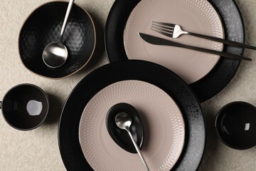 Stylish table setting. Dishes, cutlery and cups on light surface, flat lay