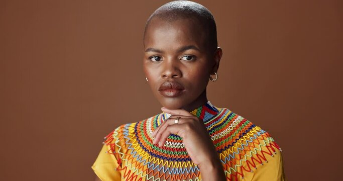 African woman, face and studio with traditional jewelry, beads necklace and clothes by brown background. Girl, person and model with indigenous fashion, color and culture in portrait with style