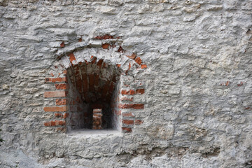 Very old window in brick stone wall of castle or fortress of 18th century. Full frame wall with...
