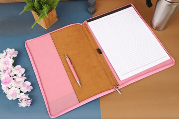 Leather Zipper Portfolio. Concept shot, top view, flap portfolio in pink colors and leather pen. Custom background flap portfolio view. Zipper portfolio on desktop.