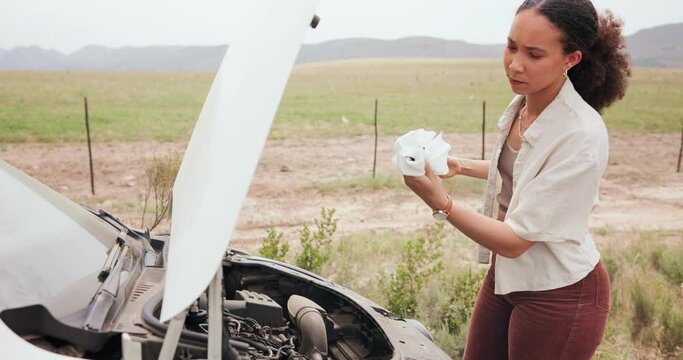 Woman, car breakdown and check oil with dipstick, engine pr thinking for problem solving, stress or solution. Person, stick and toilet paper for vehicle inspection for liquid, emergency and crisis