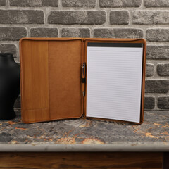 Leather Zipper Portfolio. Concept shot, top view, flap portfolio in bamboo colors and leather pen. Custom background flap portfolio view. Zipper portfolio on desktop. Free space on white paper.