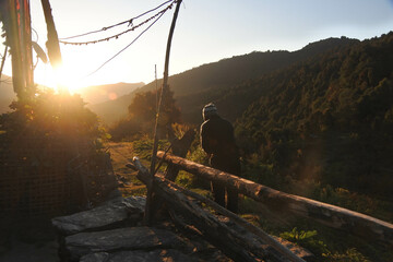 A man is enjoying the morning sunshine on the hiking trail to Annapurna Base Camp.