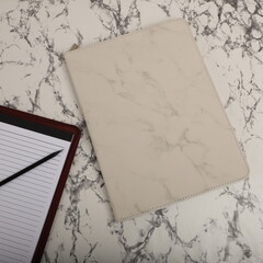 Leather Zipper Portfolio. Concept shot, top view, flap portfolio in white marble pattern  colors and leather pen. Marble background flap portfolio view. Zipper portfolio on desktop. Blank space.