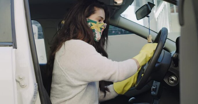 Woman, wipe and cleaning steering wheel in car, disinfection and bacteria prevention in covid. Female person, seatbelt and face mask for protection in pandemic, security and safety or compliance