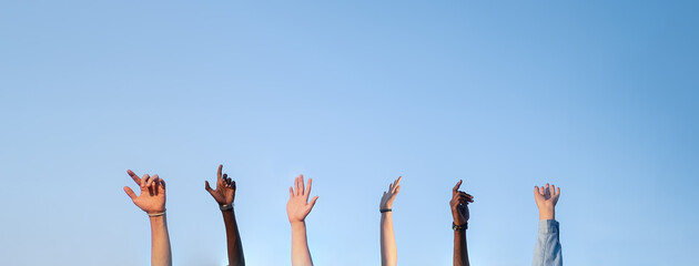 People hands and arms raised isolated on a blue background.