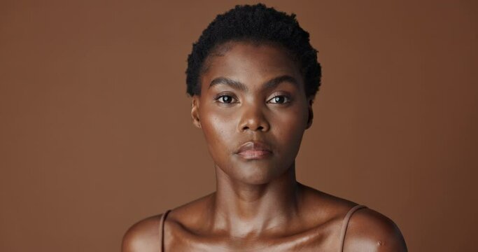 Face of black woman, natural beauty or aesthetic for wellness, cosmetics or healthy skin in studio. Dermatology, pride or serious African girl model with glow or skincare results on brown background