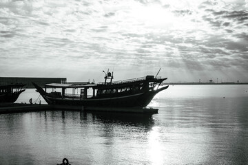 Fototapeta premium Black and white photo of Traditional boats called Dhows are anchored in the old Doha port