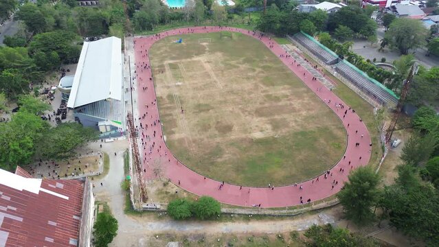 Aerial view of people running at the GOR Nani Wartabone, Gorontalo City. Group of people on the running track, the football field, or the soccer field. 
