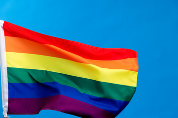 Rainbow flag waving on blue background