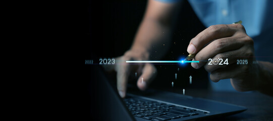 Countdown to 2024 concept. the taps a virtual download bar with a loading progress meter on New Year's Eve, turning the year 2023 to 2024.