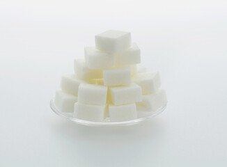 Sugar cubes on a plate on white background