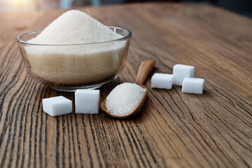 A bowl granulated sugar and sugar cubes on the table