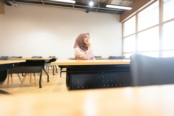 Modern Classroom: Inspired Muslim Female Teacher Wears Hijab Poses in a small classroom There is a...