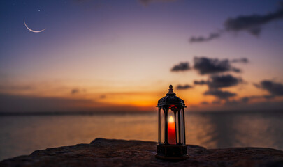 Lantern lamp on sand beach sunset sky blurred crescent over sea in the evening, Religion well space...