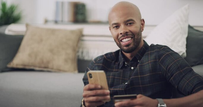 Man, phone and credit card on sofa with online shopping for banking, fintech and internet payment in living room. Black person, smartphone and happy for web transaction or discount on sale website