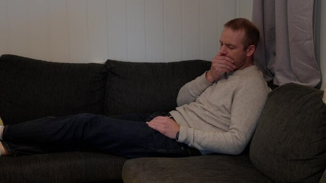 Sick Day, Man Coping with Cold and Flu Symptoms in Sofa Corner