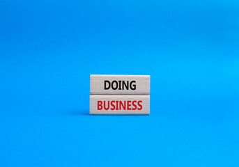 Doing Business symbol. Concept word Doing Business on wooden blocks. Beautiful blue background. Business and Doing Business concept. Copy space