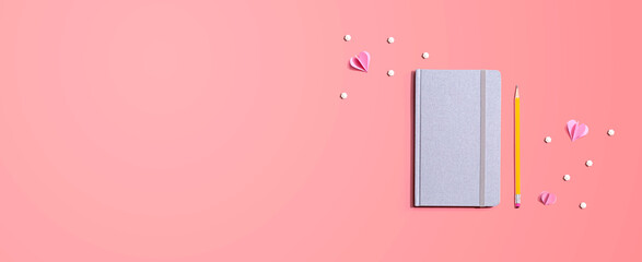 Gray notebook with paper hearts - flat lay