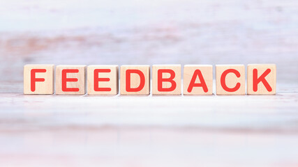 Feedback word made of wooden cubes on a light background
