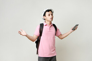 Asian man backpacker hold mobile phone with confused expression. travelling concept. on isolated...