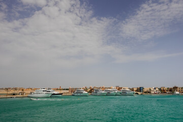 Naklejka na ściany i meble green water and white boats in port ghalib in the desert