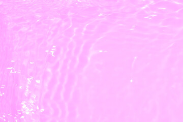 Pink water splashes on the surface ripple blur. Defocus blurred transparent pink colored clear calm water surface texture with splash and bubble. Water waves with shining pattern texture background