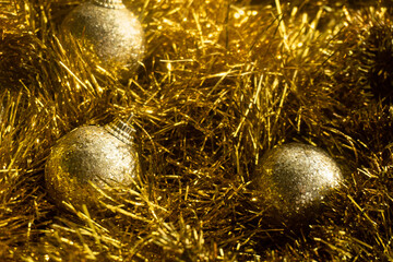 Christmas tree decoration lies on golden tinsel