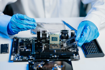 The technician is putting the CPU on the socket of the computer motherboard. electronic engineering...