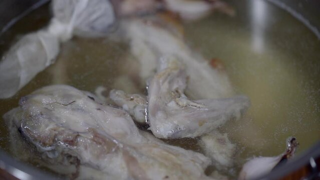 Close-up shot of chicken boiling in a pot with ingredients