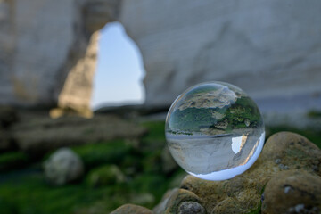 Chalk cliffs of Etretat seen through glass sphere