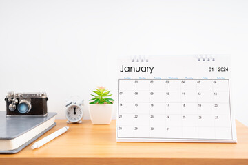 Desktop Calendar for January 2024 year and vintage camera with diary for Planner to plan timetable.