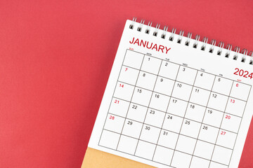 January 2024 desk calendar on red background.