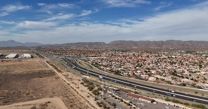 Drone View of Light Traffic on highway in Phoenix, Arizona. Partially overcast sky over mountains in late fall. Arizona Loop 202 in Front of South Mountain.