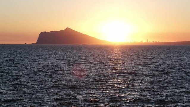 Sunset on the coastal city of Calp with a view of Benidorm. The coast of the Mediterranean Sea. Sunset on Costa Blanca. 